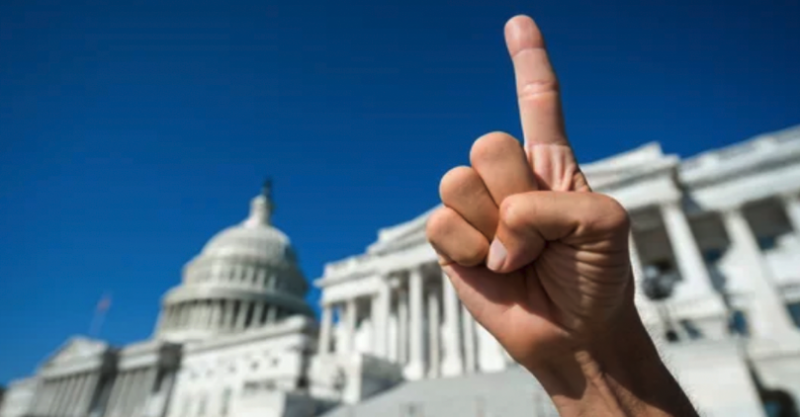 Finger raised in front of the Capital to represent the first amendment 