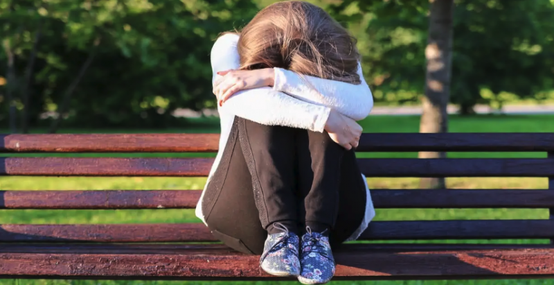 Image from America Out Loud post of sad girl on a bench