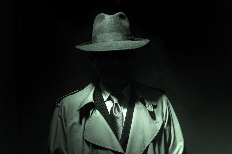 Image of investigator with trench coat and hat