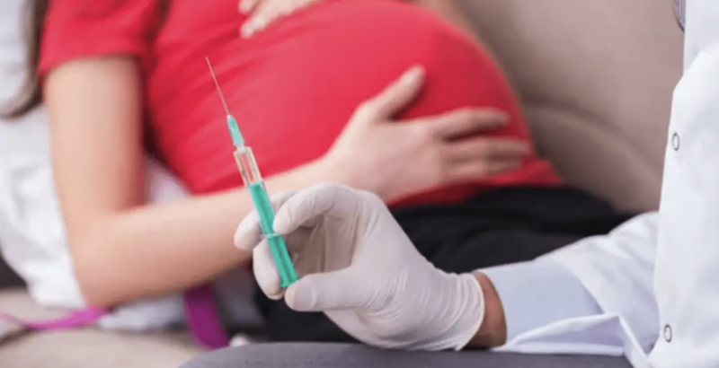 Image of pregnant woman and a vaccine